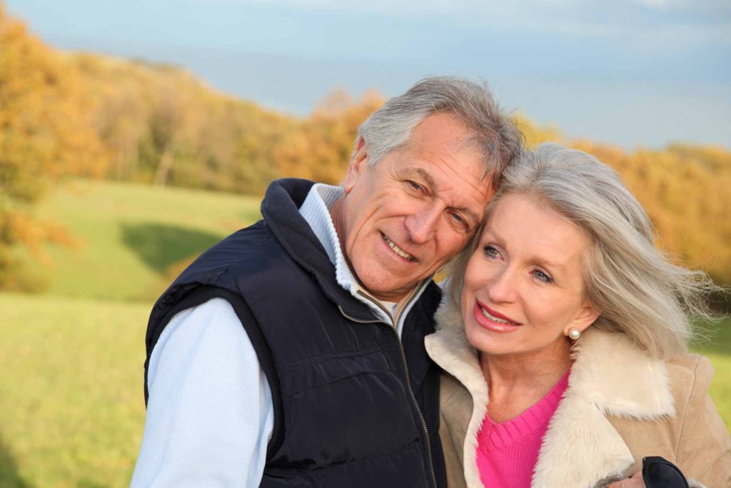 Photo of happy older couple with wind in their hair.